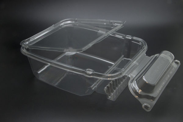 A clear plastic container with a lid on a black surface.