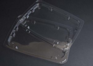Two clear plastic containers on a black surface.