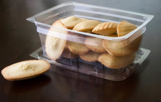 A plastic container with cookies in it on a table.